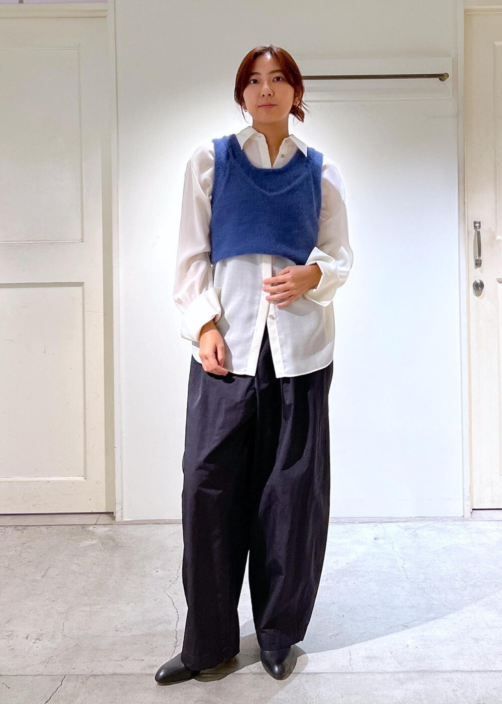 ブルー系のタンクトップ、ホワイト系のシャツ/ブラウス、ブラック系のブーツを着用したレディースの秋コーディネートの7枚目の写真