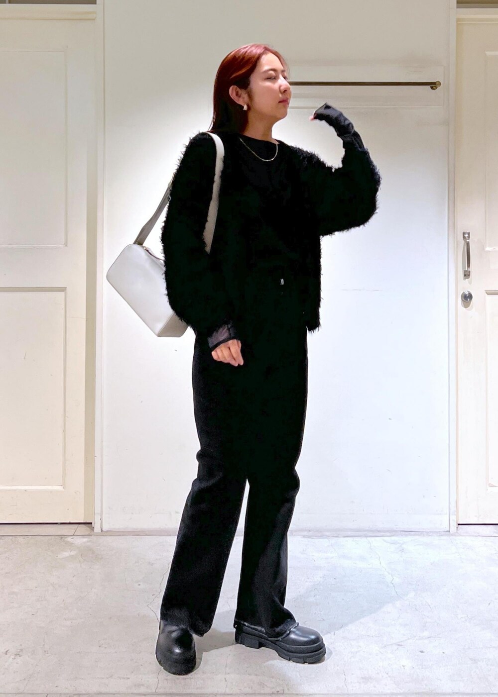 ブラック系のブーツ、ブラック系のTシャツ/カットソー、グレー系のデニムパンツを着用したレディースの秋コーディネートの4枚目の写真