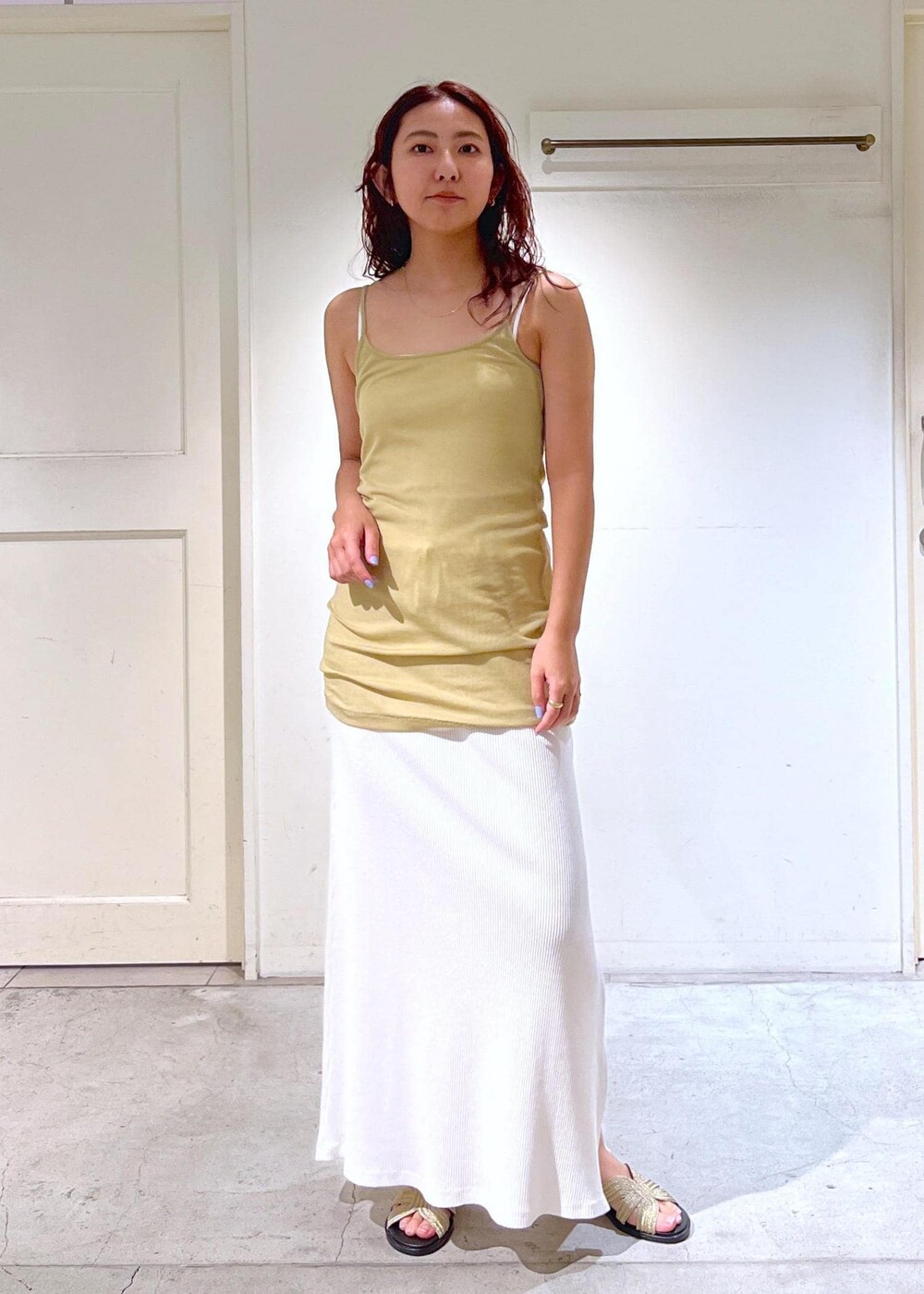 ゴールド系のサンダル、イエロー系のキャミソール、ホワイト系のTシャツ/カットソーを着用したレディースの夏コーディネートの4枚目の写真