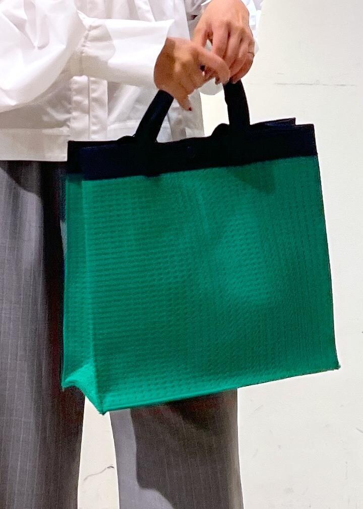 グレー系のスラックス、ホワイト系のシャツ/ブラウス、グリーン系のトートバッグを着用したレディースの夏コーディネートの6枚目の写真