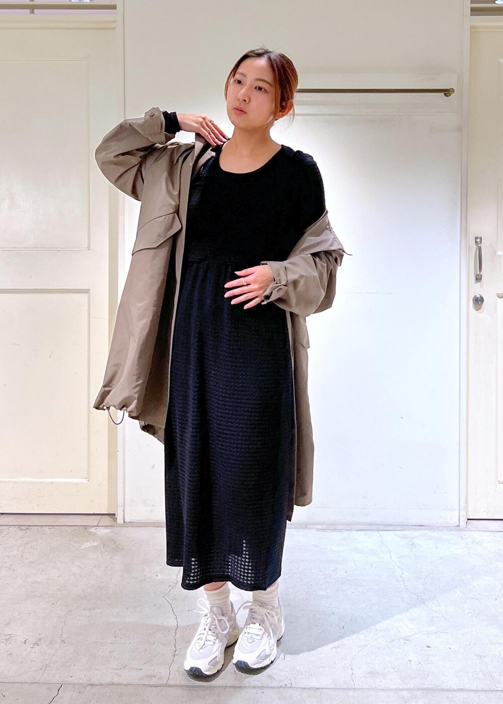 ホワイト系のスニーカー、ブラック系のスカート、ブラウン系のミリタリージャケットを着用したレディースの春コーディネートの5枚目の写真