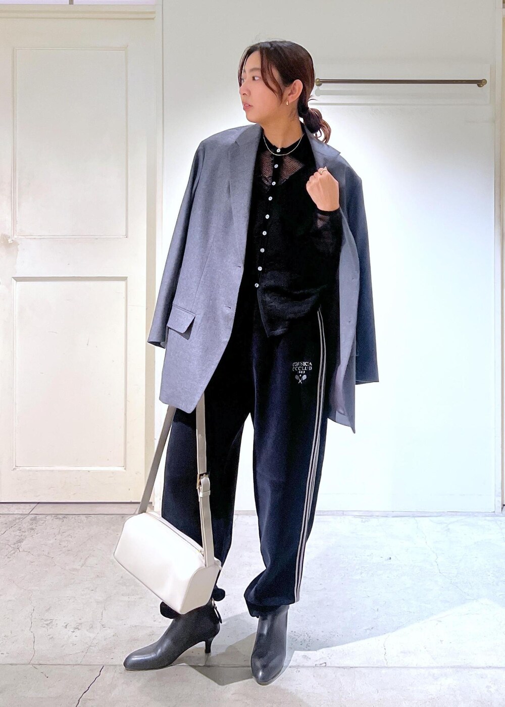 グレー系のテーラードジャケット、ブラック系のキャミソール、ブラック系のカーディガン/ボレロを着用したレディースの冬コーディネートの3枚目の写真