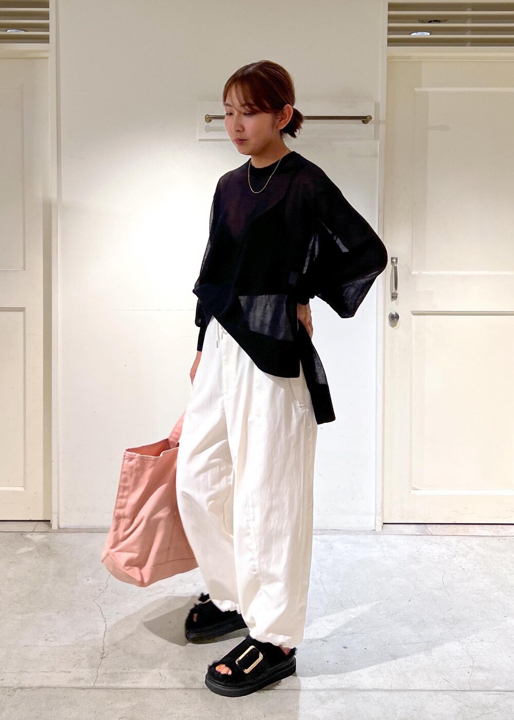 ホワイト系のカーゴパンツ、ブラック系のTシャツ/カットソー、ピンク系のトートバッグを着用したレディースの夏コーディネートの2枚目の写真