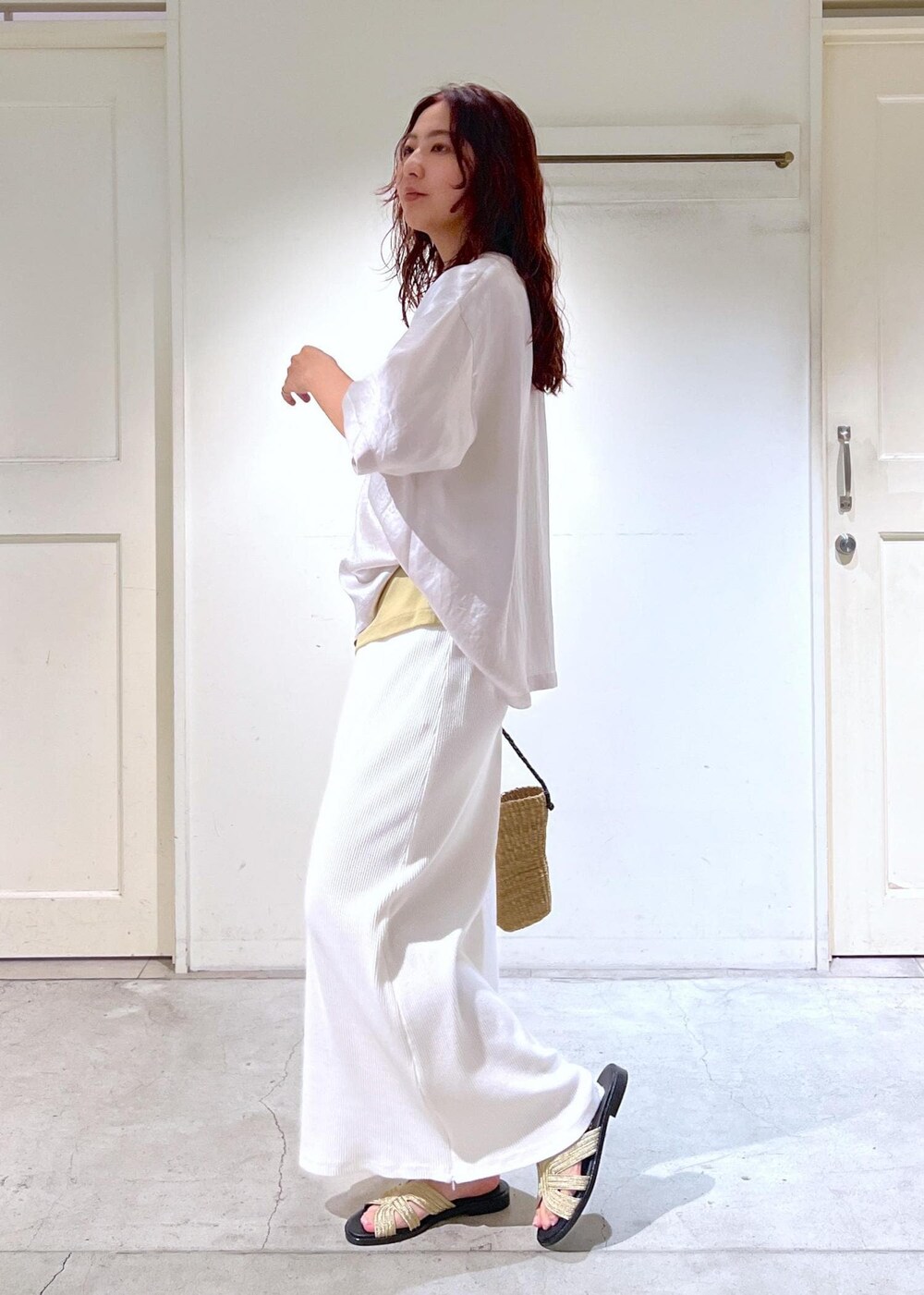 ゴールド系のサンダル、イエロー系のキャミソール、ホワイト系のTシャツ/カットソーを着用したレディースの夏コーディネートの2枚目の写真