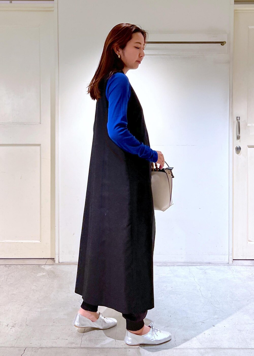 シルバー系のその他シューズ、ブラック系のジャンパースカート、グレー系のその他パンツを着用したレディースの春コーディネートの4枚目の写真