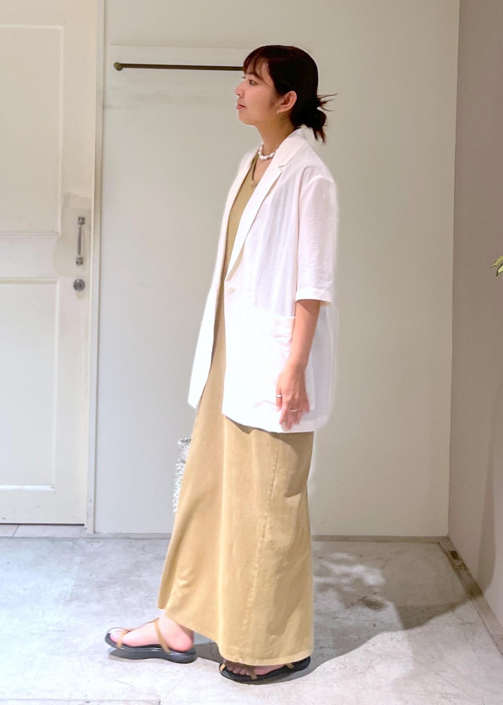 ベージュ系のサンダル、シルバー系のトートバッグ、ブラウン系のワンピースを着用したレディースの夏コーディネートの5枚目の写真