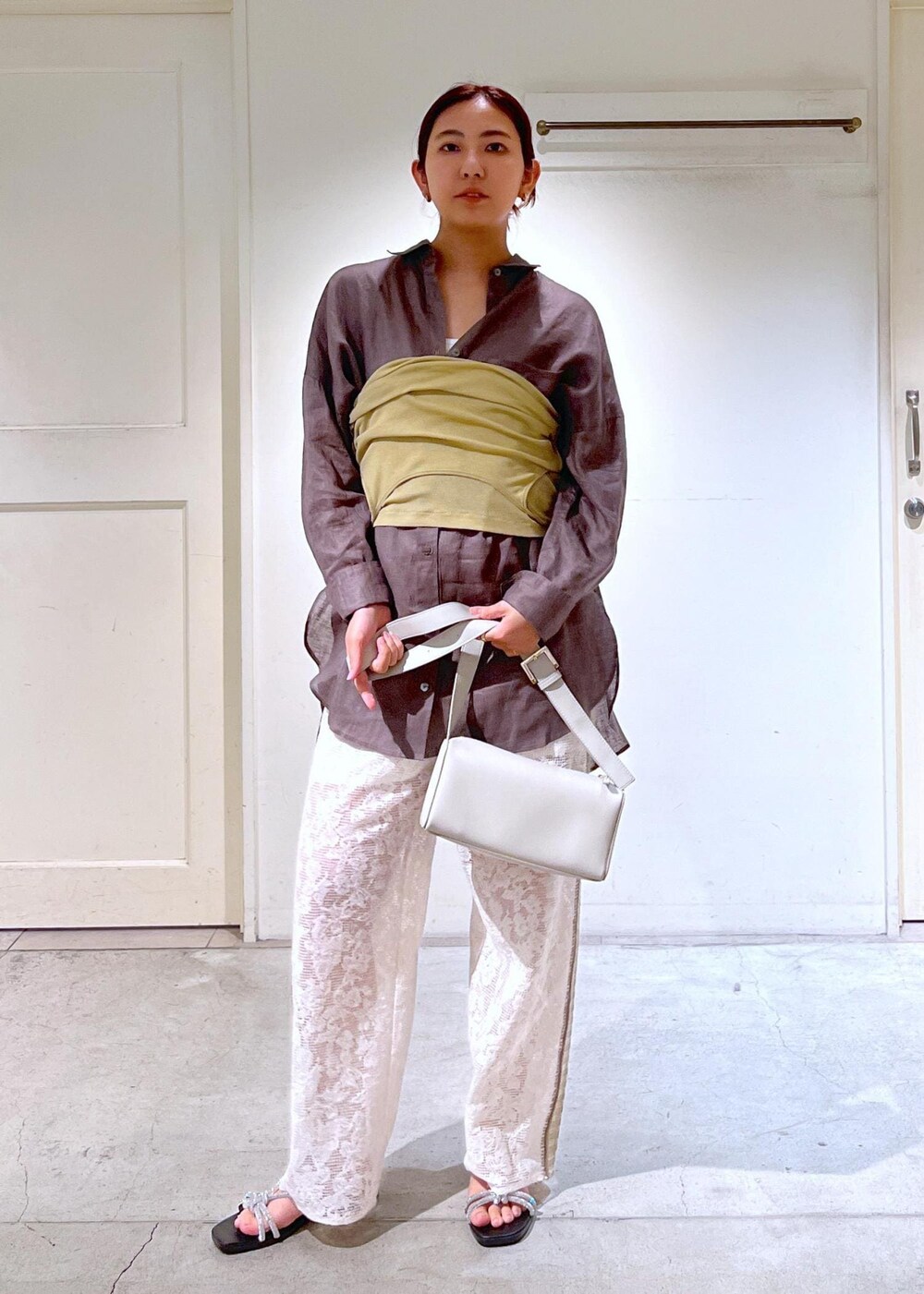 シルバー系のサンダル、ホワイト系のタンクトップ、イエロー系のキャミソールを着用したレディースの夏コーディネートの2枚目の写真