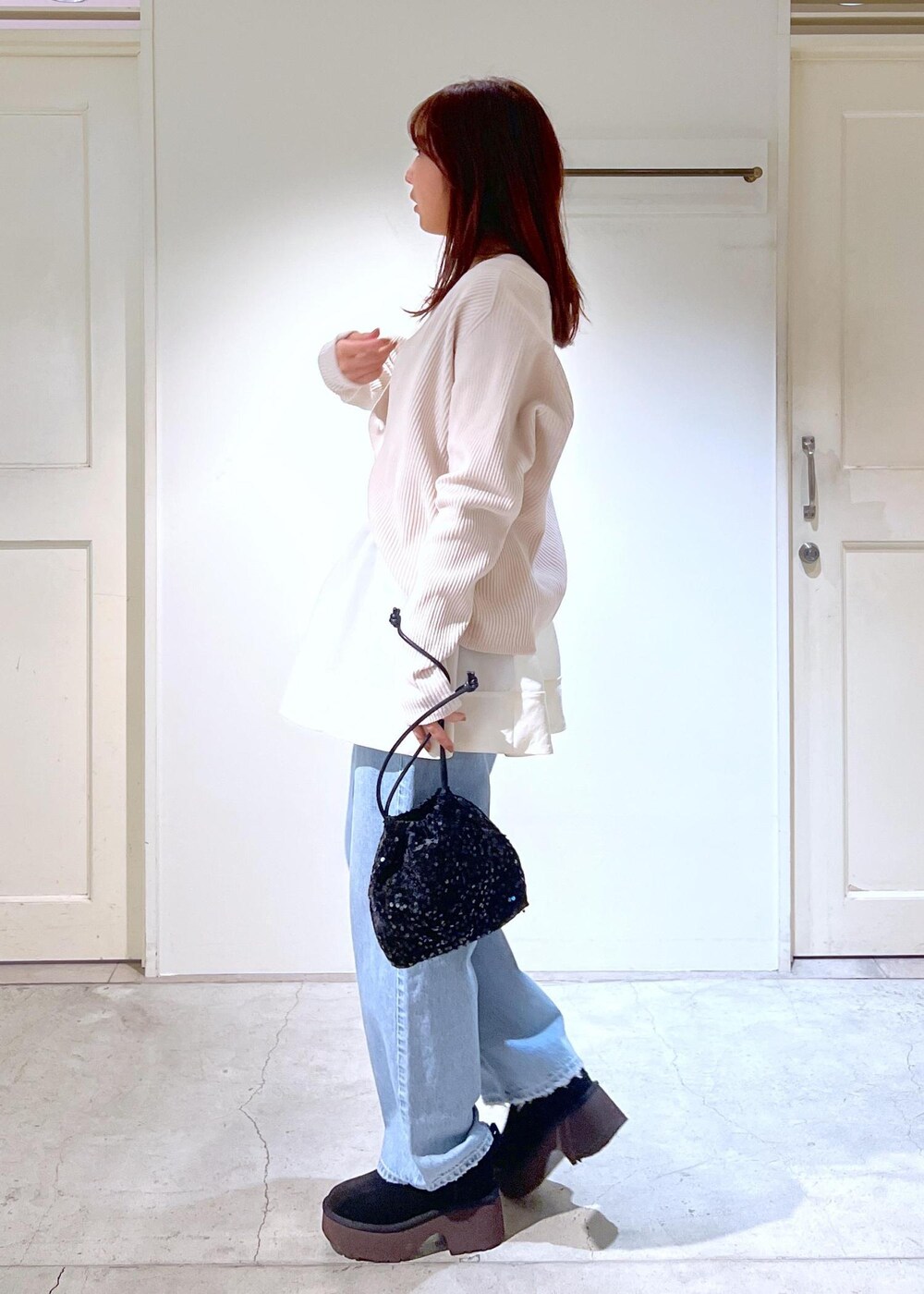 ブラック系のブーツ、ホワイト系のタンクトップ、ブラック系のハンドバッグを着用したレディースの冬コーディネートの3枚目の写真