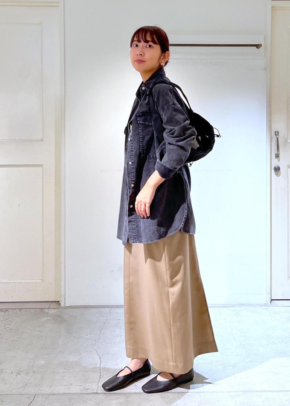 ブラック系のパンプス、グレー系のシャツ/ブラウス、ベージュ系のジャンパースカートを着用したレディースの秋コーディネートの4枚目の写真