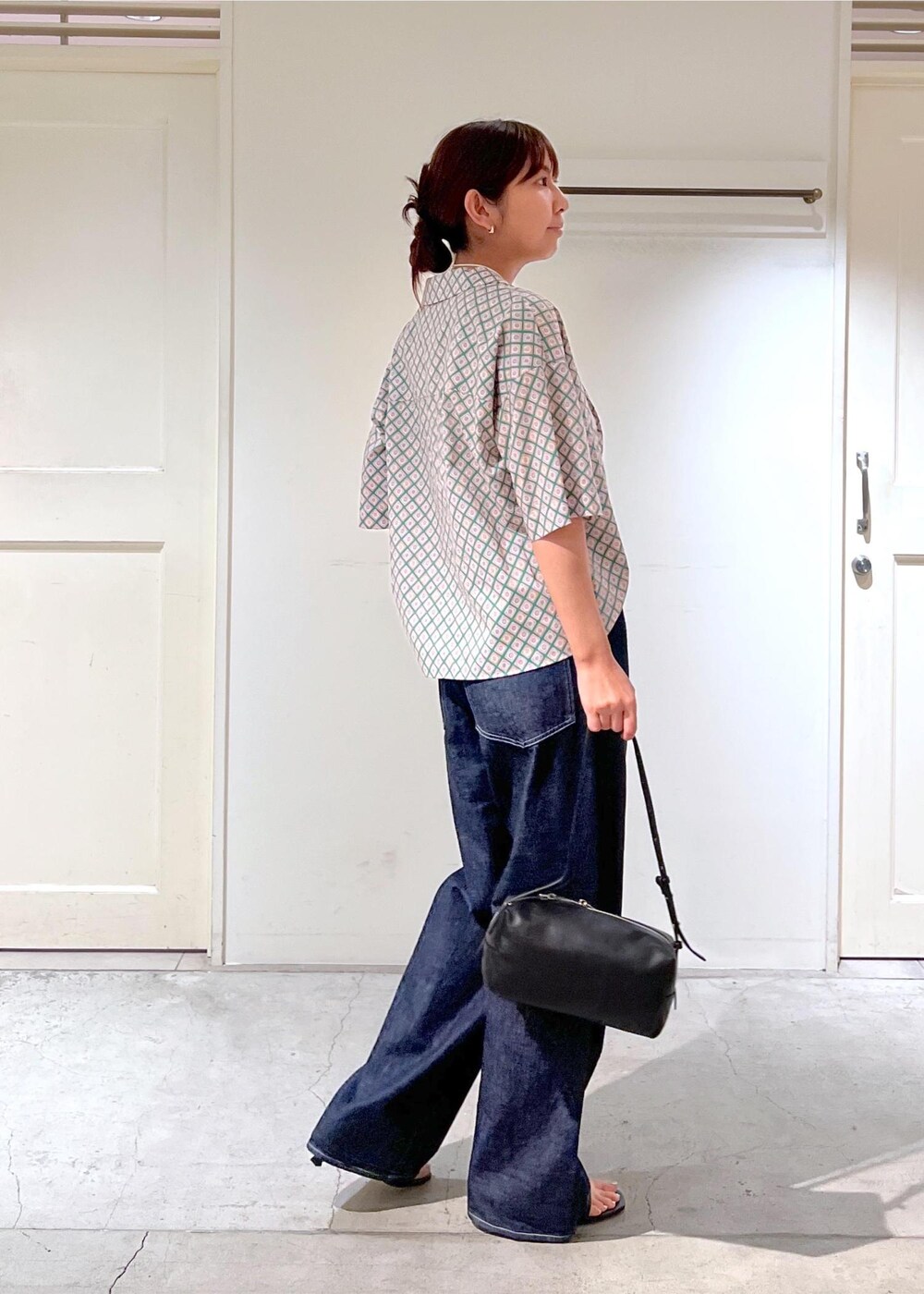 ブルー系のデニムパンツ、ブラック系のサンダル、グリーン系のシャツ/ブラウスを着用したレディースの夏コーディネートの4枚目の写真