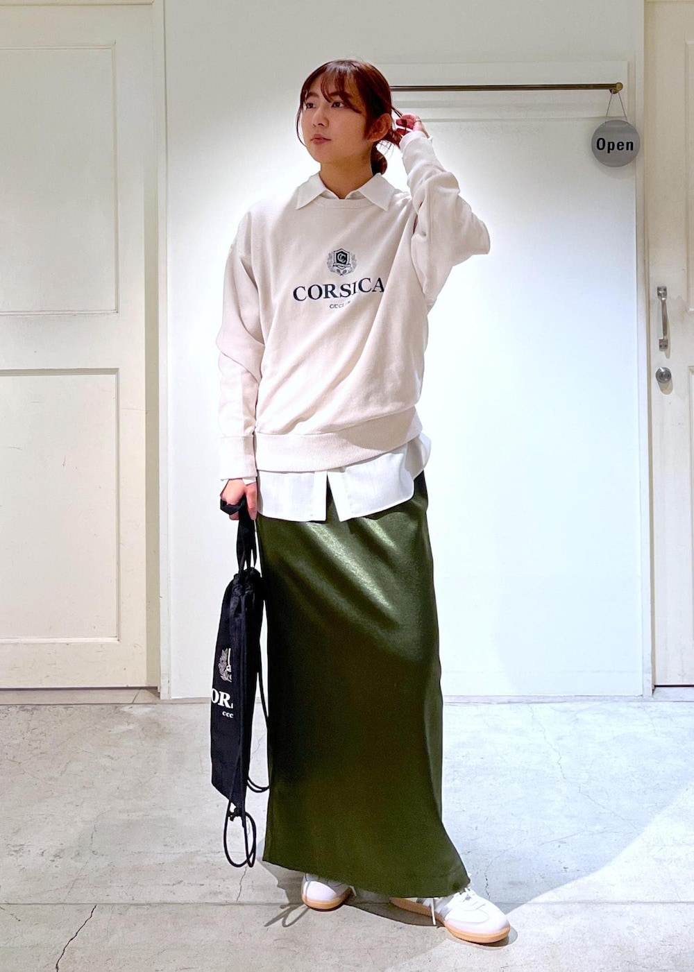 グリーン系のスカート、ホワイト系のシャツ/ブラウス、ホワイト系のスウェットを着用したレディースの冬コーディネートの2枚目の写真