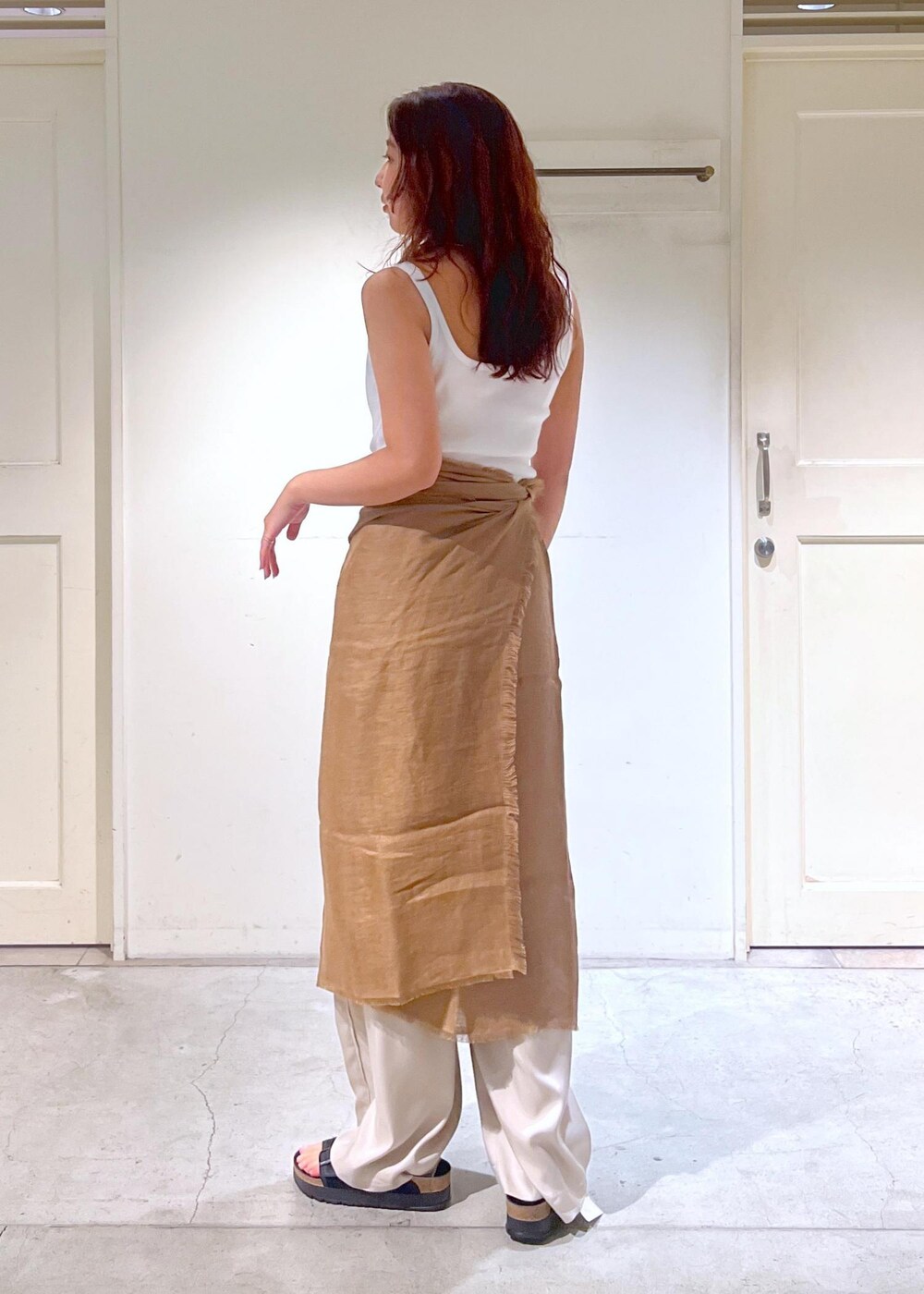 ブラック系のショルダーバッグ、ブラック系のサンダル、ホワイト系のタンクトップを着用したレディースの夏コーディネートの6枚目の写真