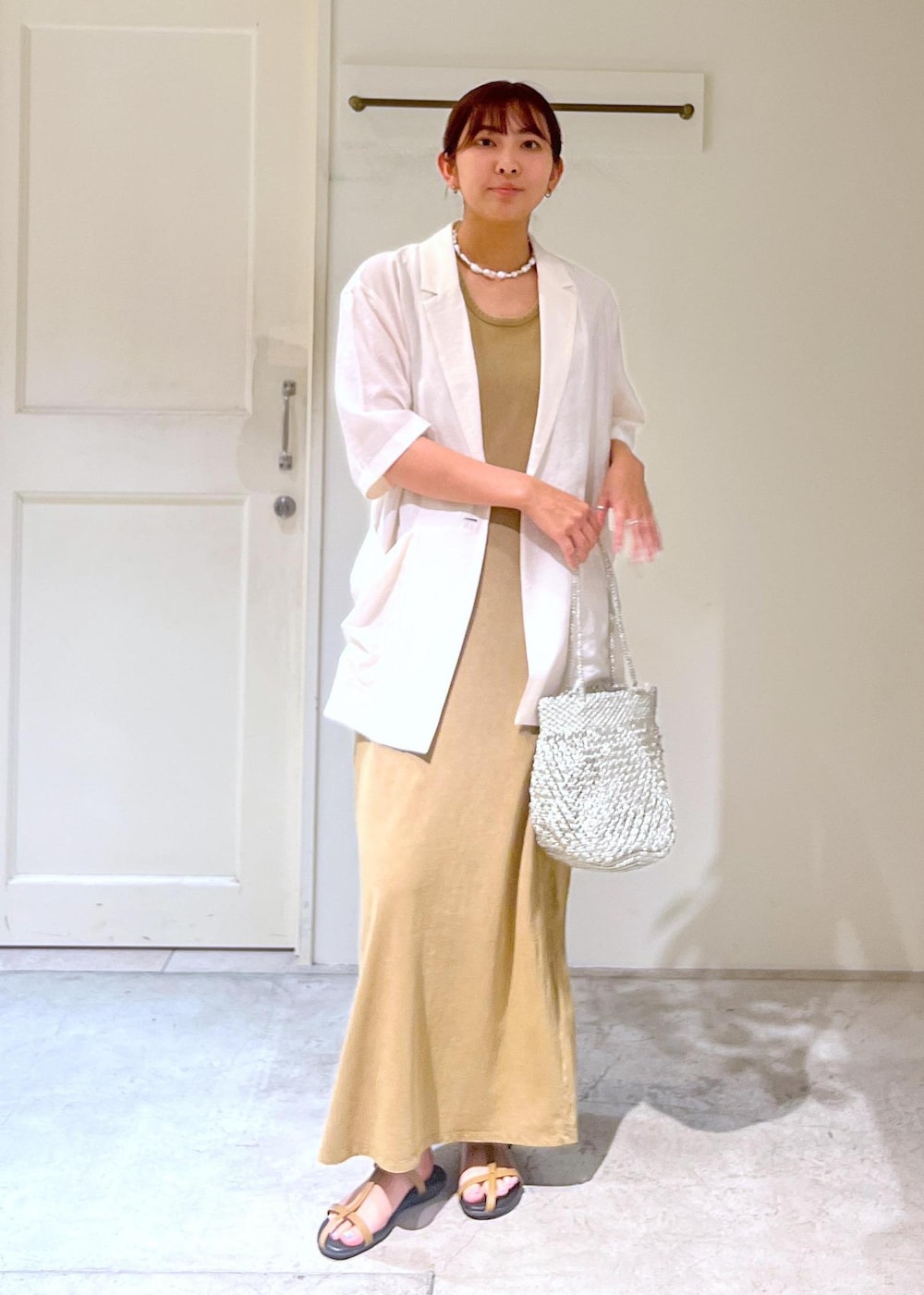 ベージュ系のサンダル、シルバー系のトートバッグ、ブラウン系のワンピースを着用したレディースの夏コーディネートの3枚目の写真