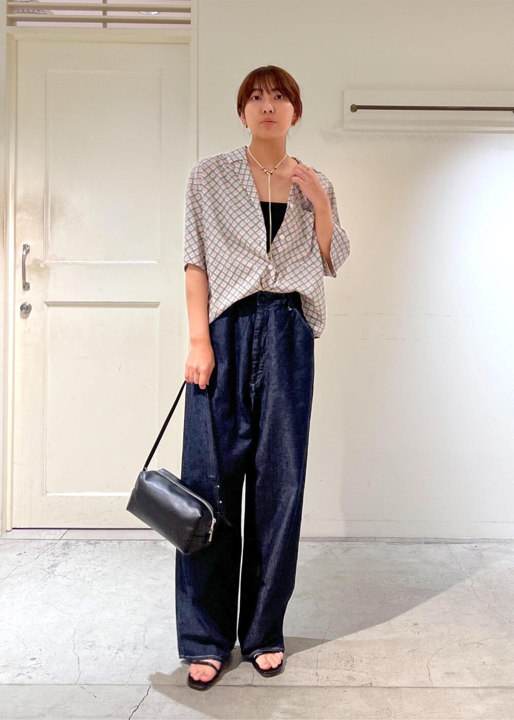 ブルー系のデニムパンツ、ブラック系のサンダル、グリーン系のシャツ/ブラウスを着用したレディースの夏コーディネートの2枚目の写真