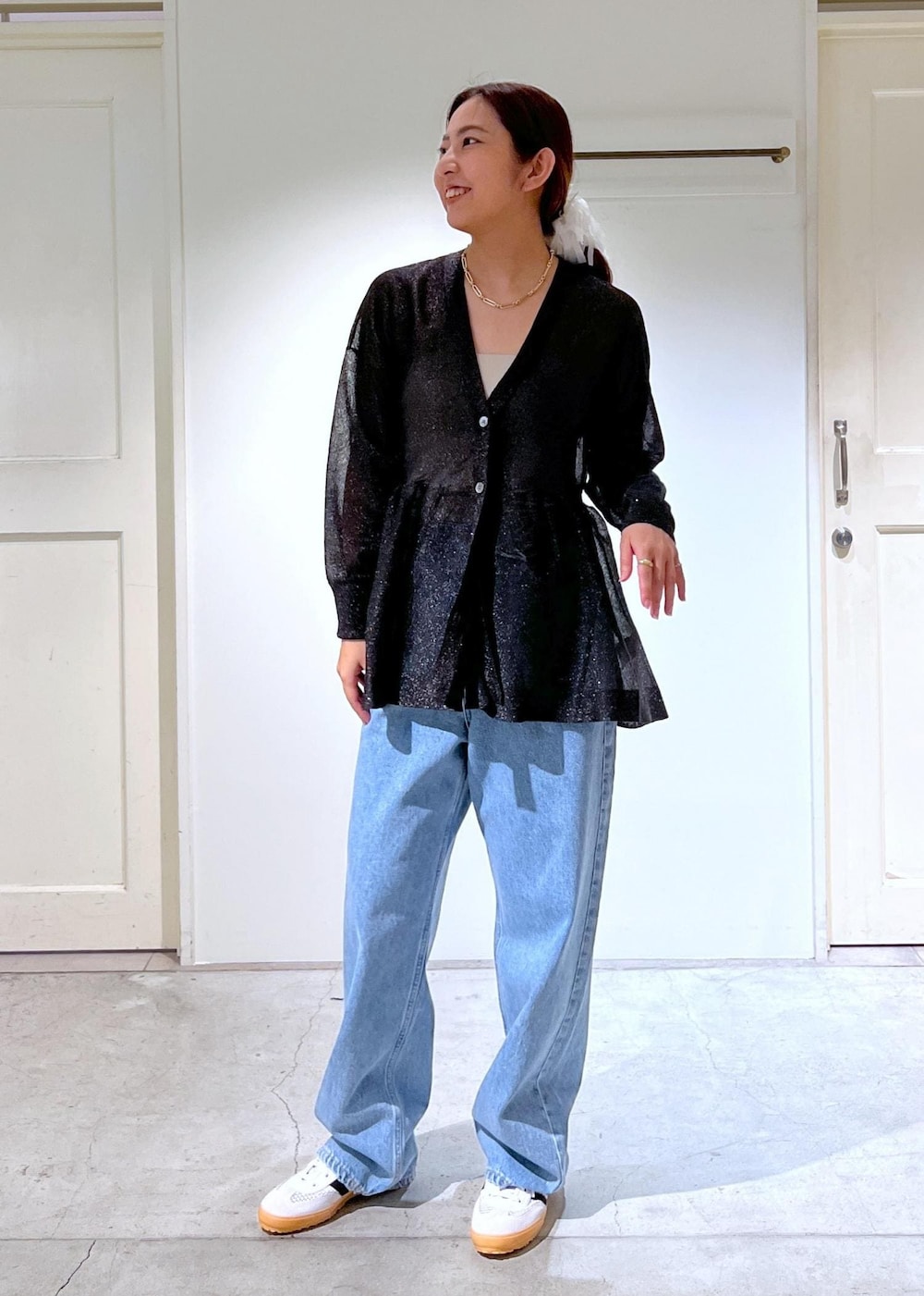 ブラック系のハンドバッグ、ブルー系のデニムパンツ、ブラック系のカーディガン/ボレロを着用したレディースの夏コーディネートの4枚目の写真