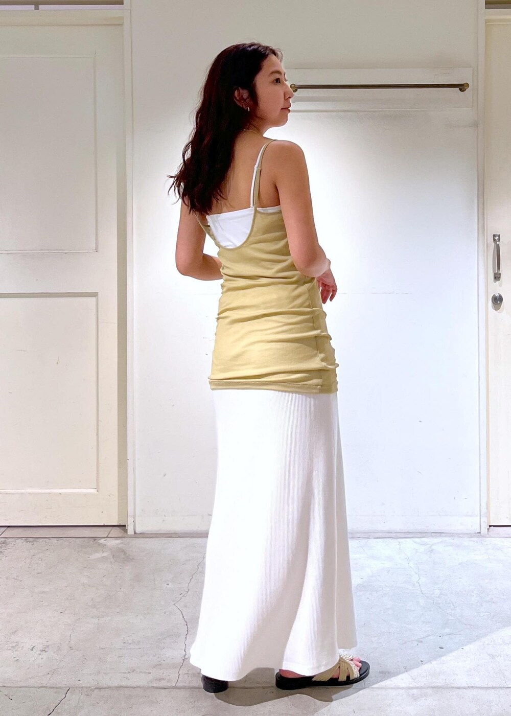 ゴールド系のサンダル、イエロー系のキャミソール、ホワイト系のTシャツ/カットソーを着用したレディースの夏コーディネートの5枚目の写真