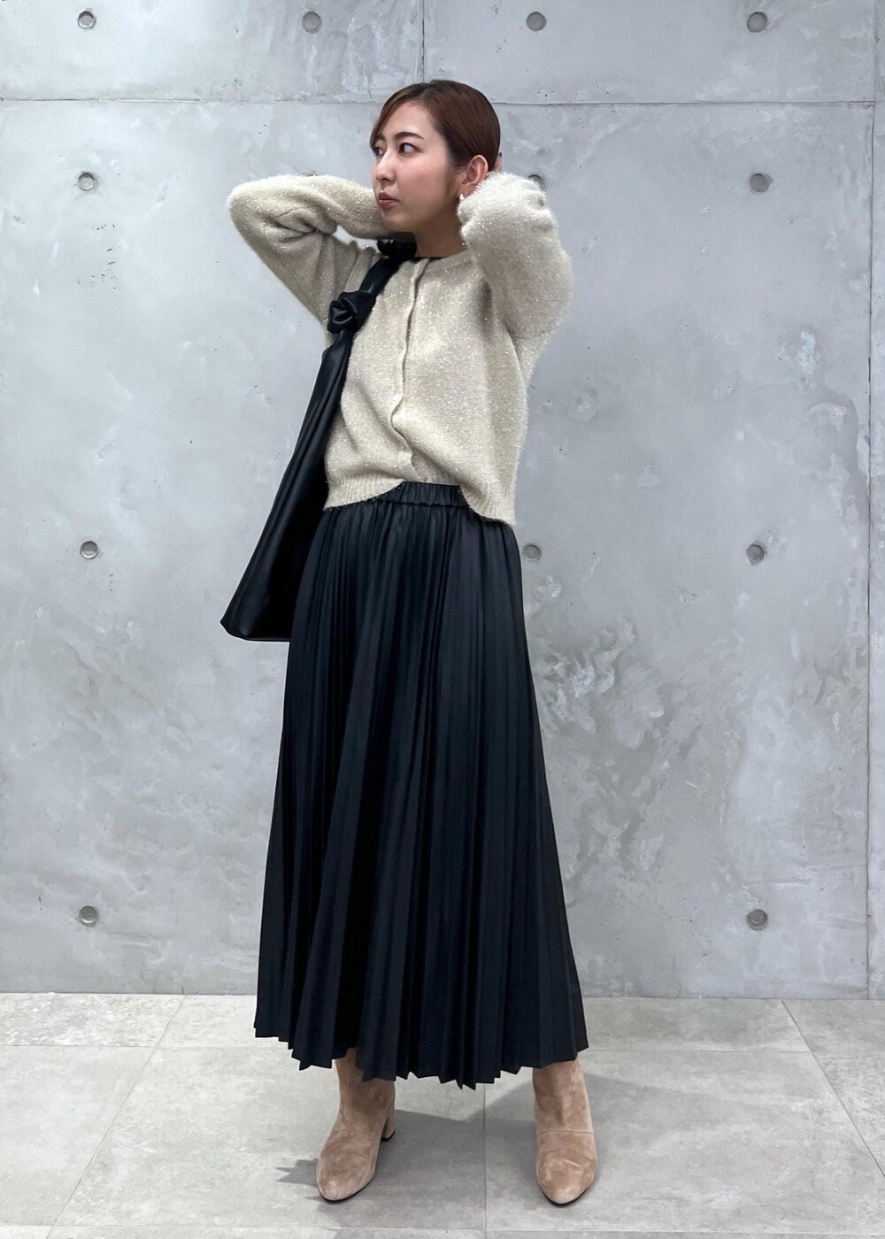 ブラウン系のブーツ、ブラック系のTシャツ/カットソー、ゴールド系のカーディガン/ボレロを着用したレディースの秋コーディネートの2枚目の写真