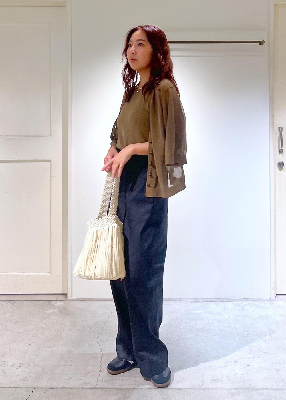 ブラック系のその他パンツ、ホワイト系のハンドバッグ、グリーン系のタンクトップを着用したレディースの夏コーディネートの2枚目の写真