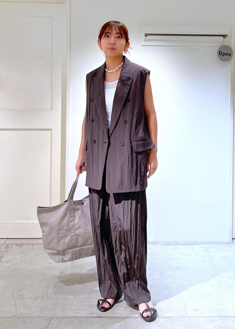 ブラック系のサンダル、ブラウン系のその他パンツ、ブラウン系のベストを着用したレディースの夏コーディネートの3枚目の写真