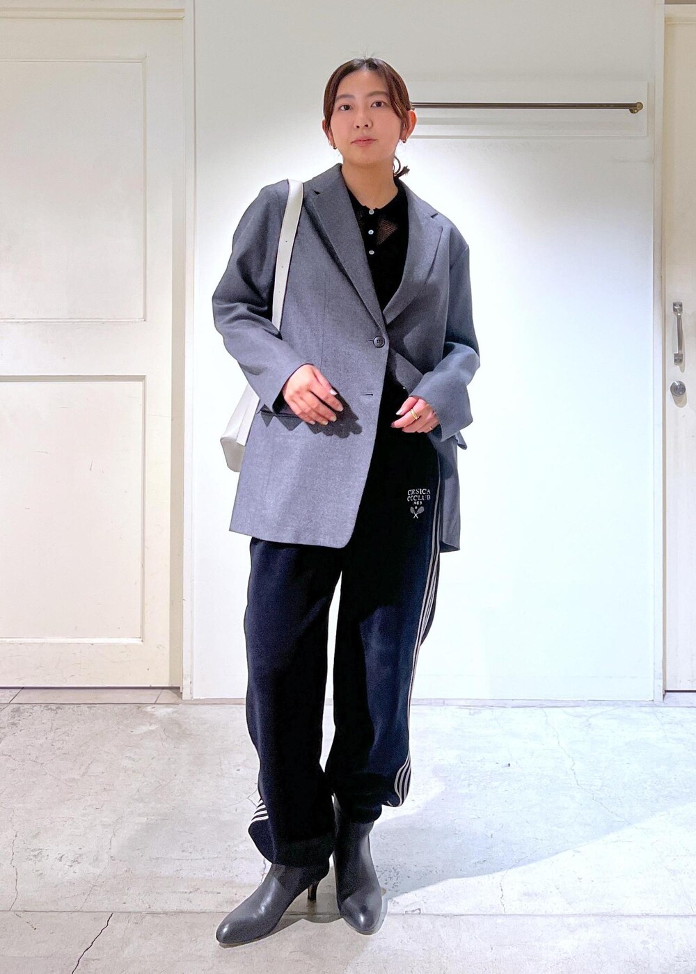 グレー系のテーラードジャケット、ブラック系のキャミソール、ブラック系のカーディガン/ボレロを着用したレディースの冬コーディネートの4枚目の写真