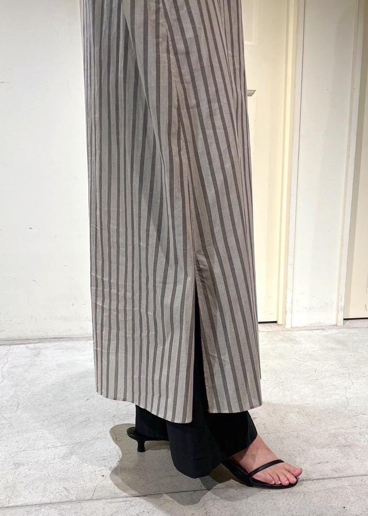 ブラック系のサンダル、ホワイト系のシャツワンピース、ブラック系のデニムパンツを着用したレディースの夏コーディネートの5枚目の写真