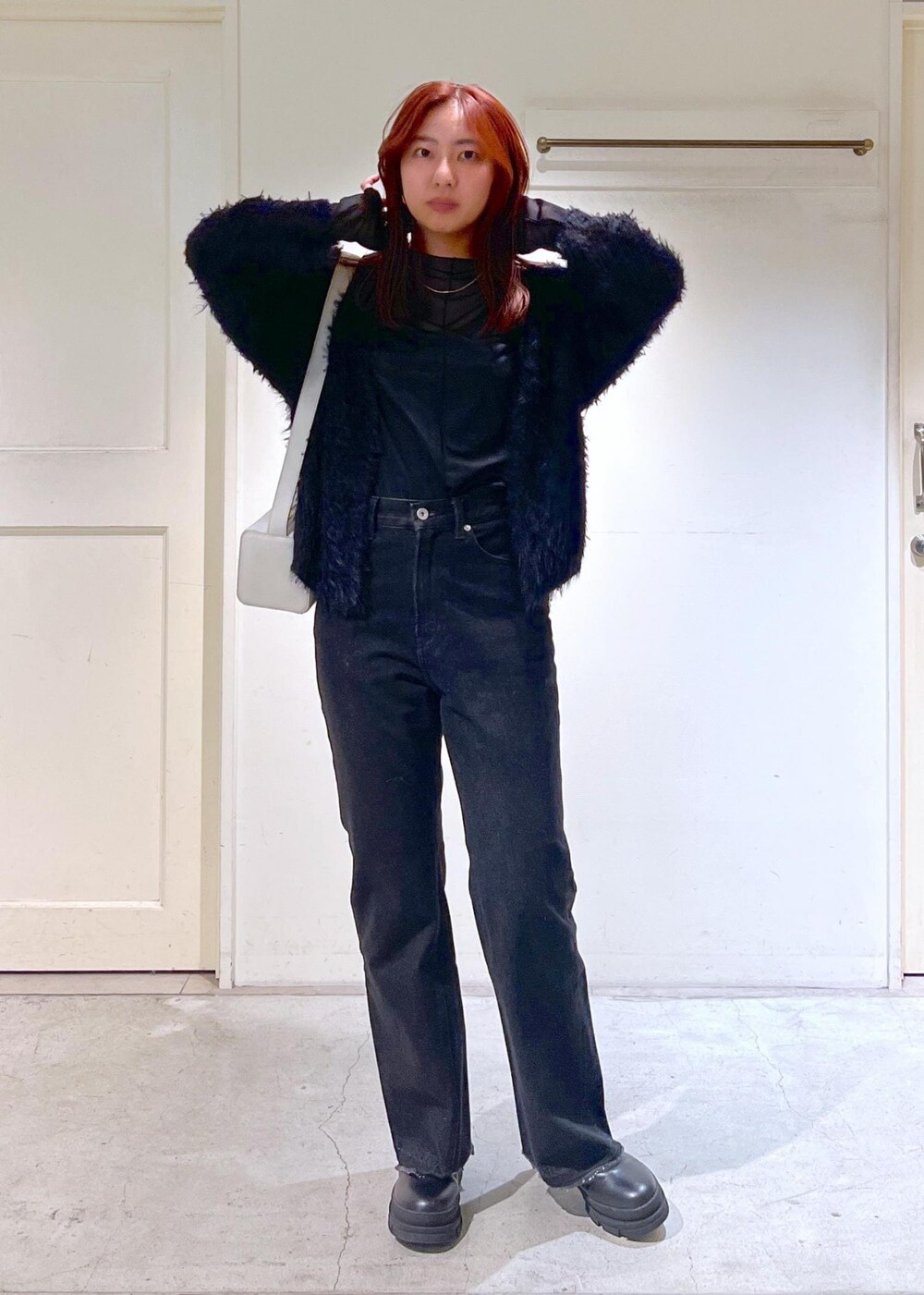 ブラック系のブーツ、ブラック系のTシャツ/カットソー、グレー系のデニムパンツを着用したレディースの秋コーディネートの3枚目の写真