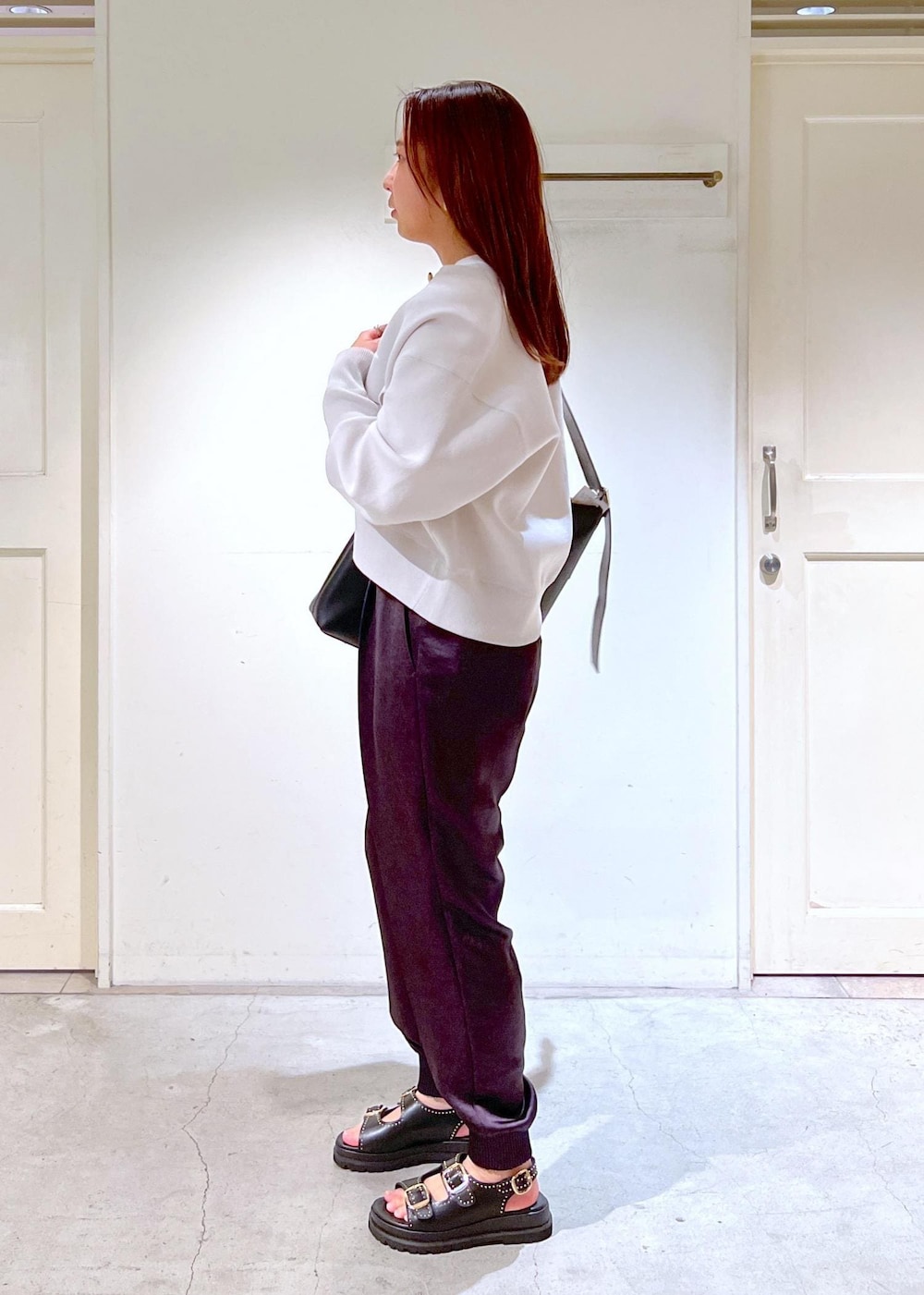 グレー系のその他パンツ、ブラック系のショルダーバッグ、ホワイト系のTシャツ/カットソーを着用したレディースの春コーディネートの3枚目の写真