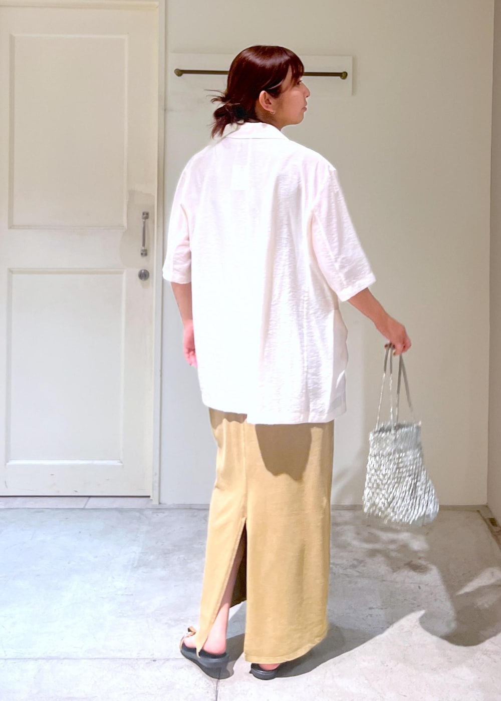 ベージュ系のサンダル、シルバー系のトートバッグ、ブラウン系のワンピースを着用したレディースの夏コーディネートの4枚目の写真