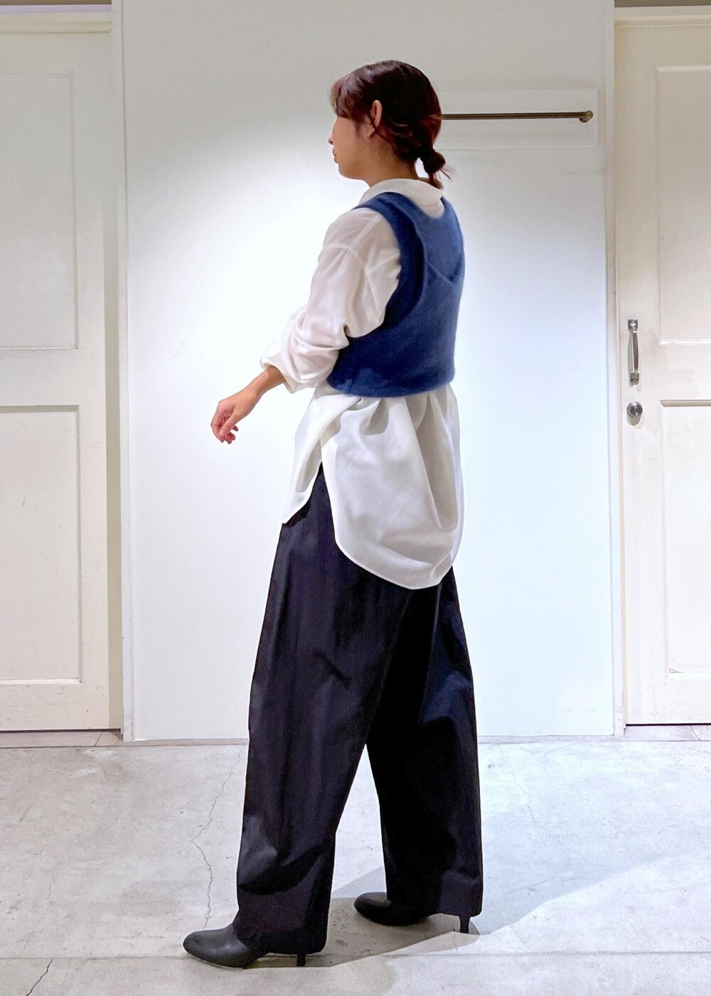 ブルー系のタンクトップ、ホワイト系のシャツ/ブラウス、ブラック系のブーツを着用したレディースの秋コーディネートの8枚目の写真