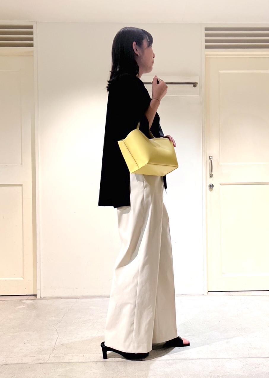 イエロー系のショルダーバッグ、ブラック系のサンダル、ホワイト系のその他パンツを着用したレディースの夏コーディネートの2枚目の写真