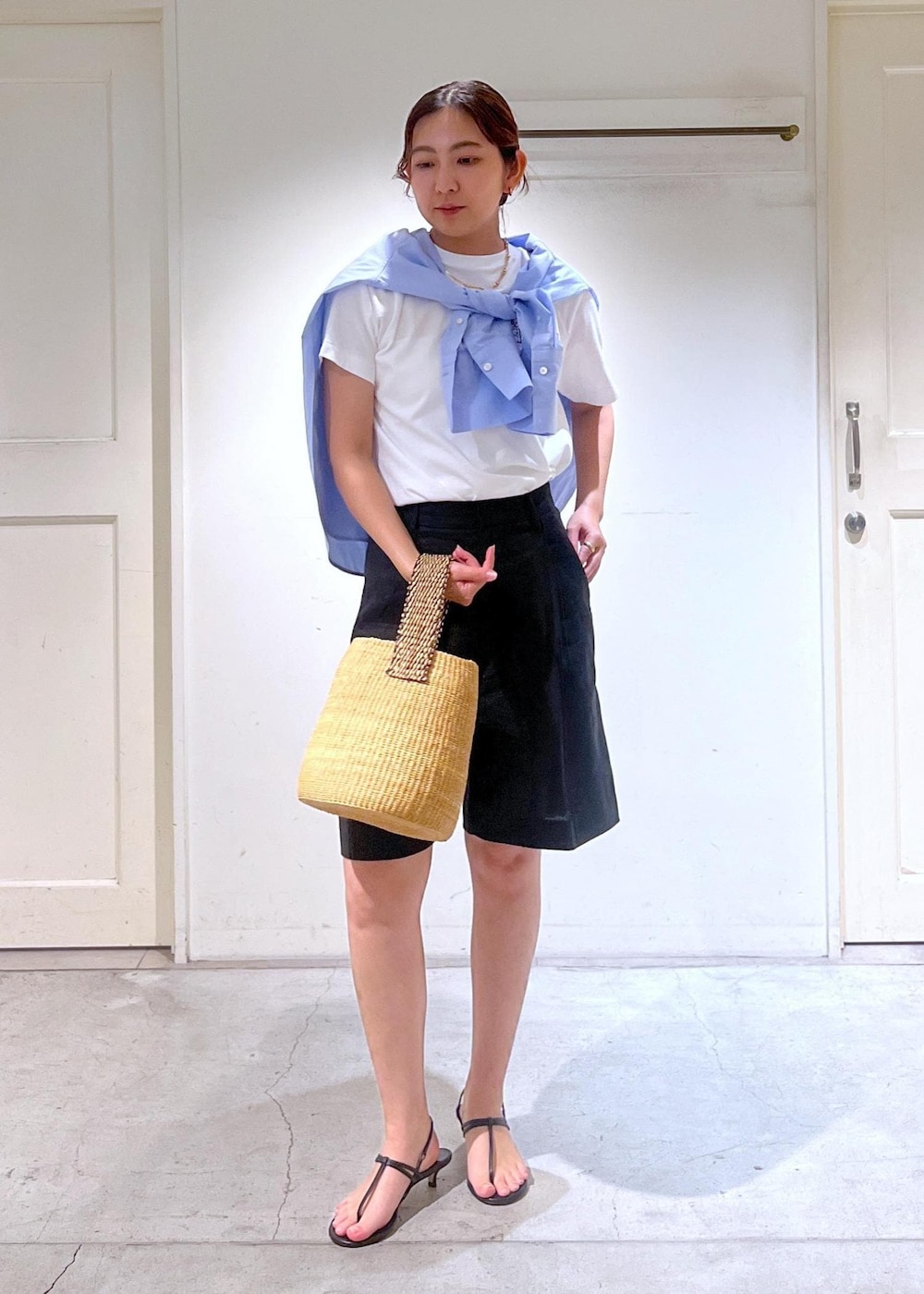 ブラック系のサンダル、ホワイト系のTシャツ/カットソー、ベージュ系のかごバッグを着用したレディースの春コーディネートの4枚目の写真