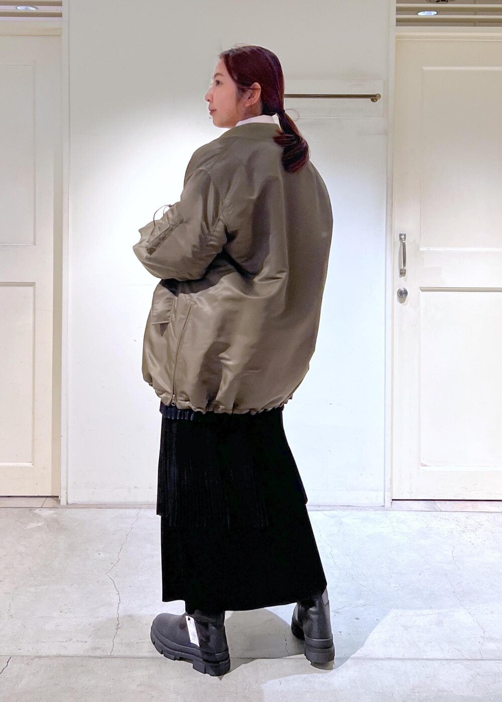 ブラック系のショルダーバッグ、グリーン系のMA-1、ブラック系のスカートを着用したレディースの冬コーディネートの4枚目の写真