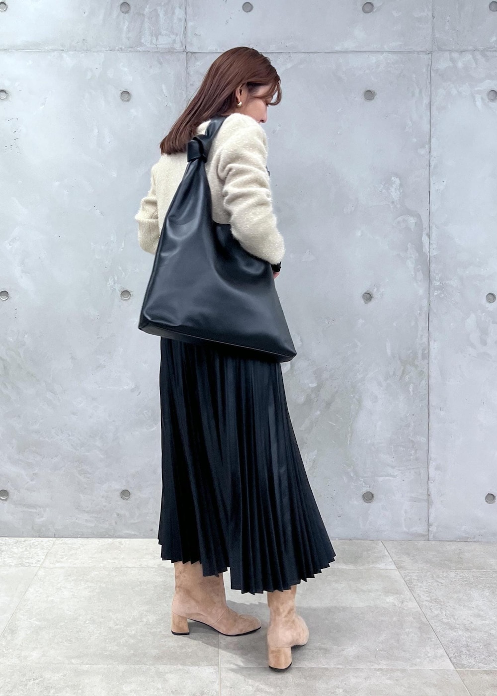 ブラウン系のブーツ、ブラック系のTシャツ/カットソー、ゴールド系のカーディガン/ボレロを着用したレディースの秋コーディネートの4枚目の写真