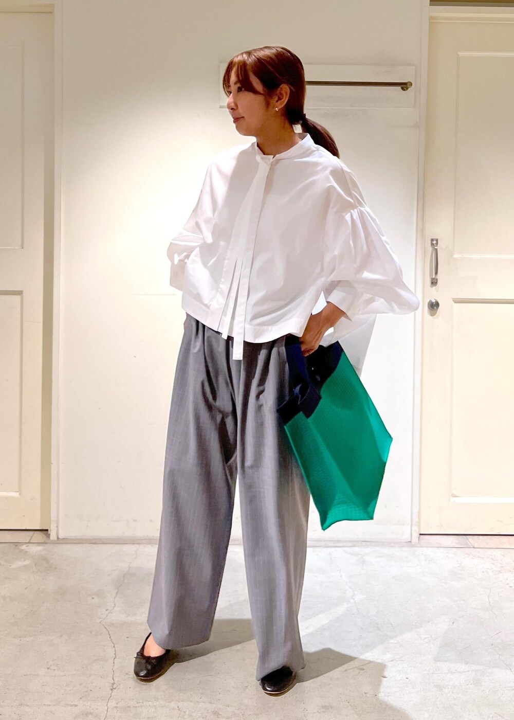 グレー系のスラックス、ホワイト系のシャツ/ブラウス、グリーン系のトートバッグを着用したレディースの夏コーディネートの5枚目の写真