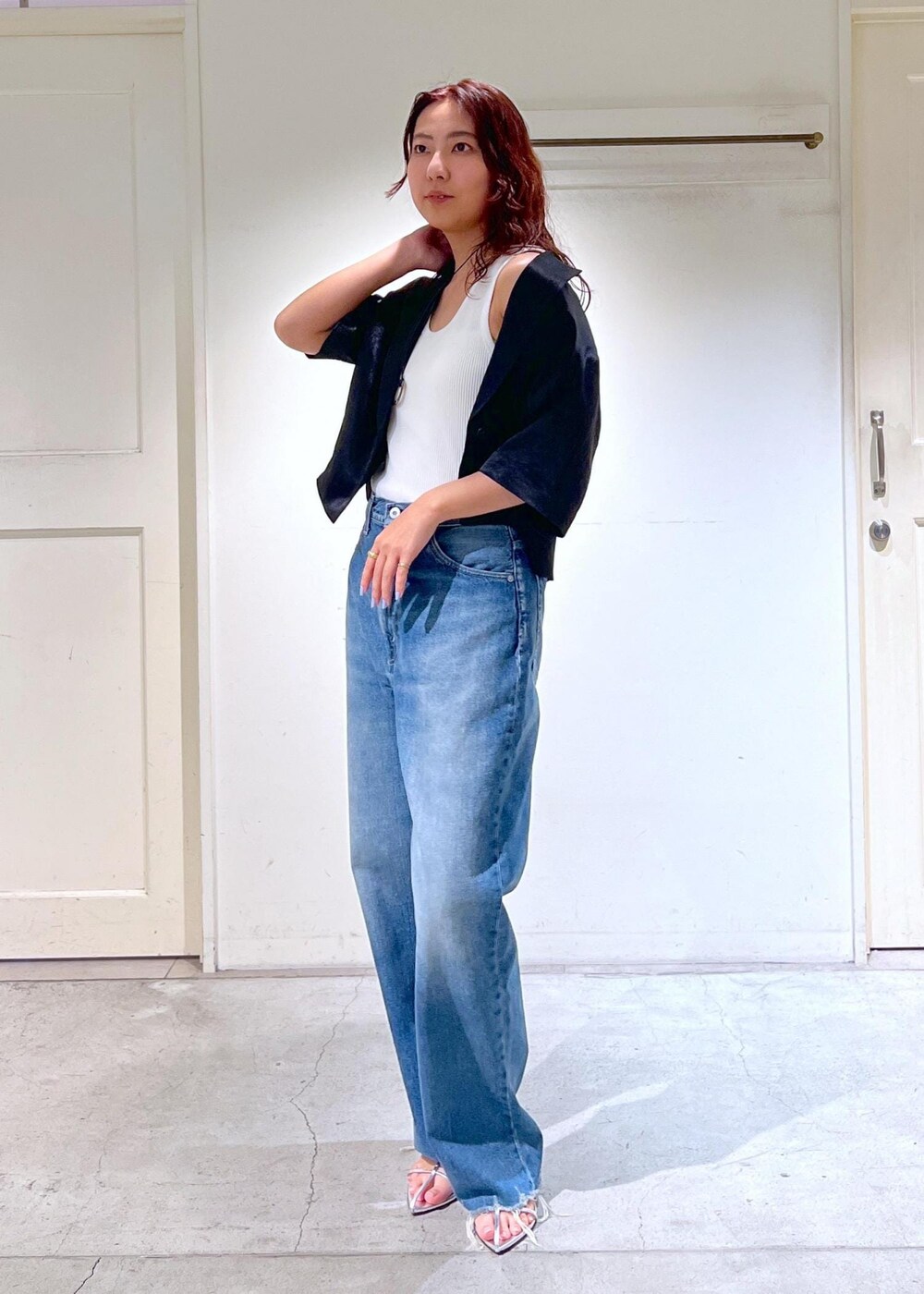 ブルー系のデニムパンツ、シルバー系のサンダル、ホワイト系のかごバッグを着用したレディースの夏コーディネートの4枚目の写真