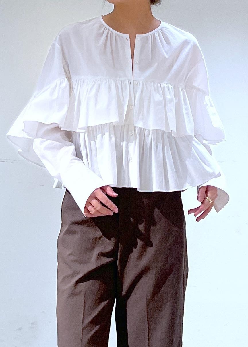 ブラウン系のスラックス、ブラウン系のローファー、ホワイト系のシャツ/ブラウスを着用したレディースの冬コーディネートの3枚目の写真