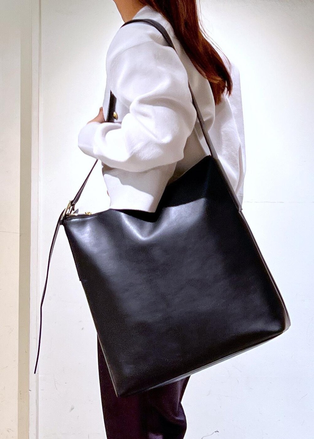 グレー系のその他パンツ、ブラック系のショルダーバッグ、ホワイト系のTシャツ/カットソーを着用したレディースの春コーディネートの7枚目の写真