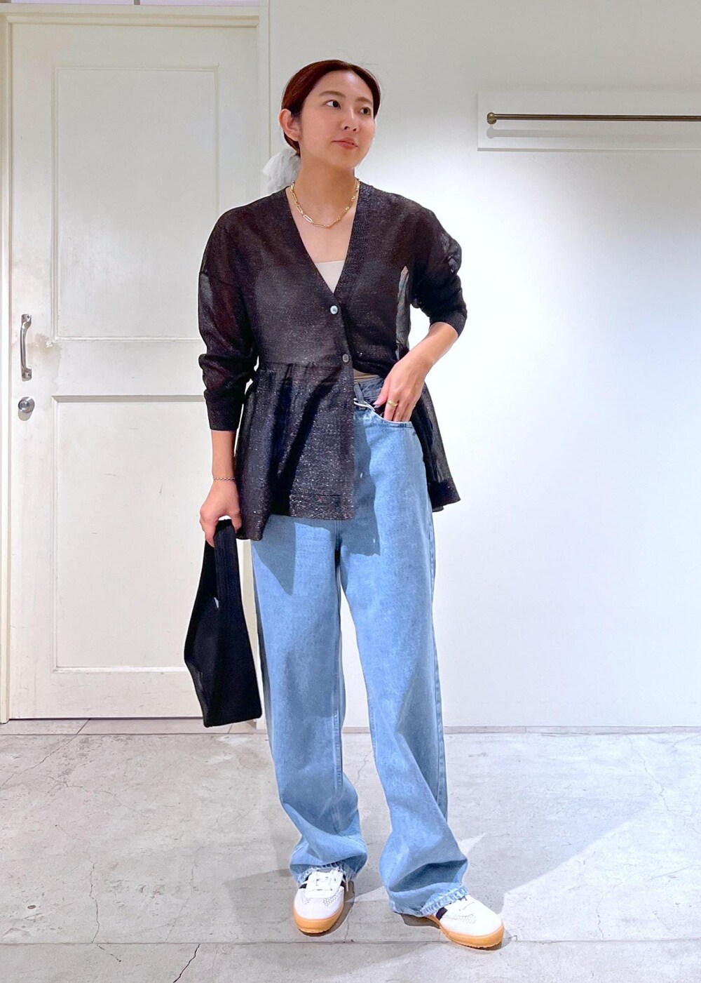 ブラック系のハンドバッグ、ブルー系のデニムパンツ、ブラック系のカーディガン/ボレロを着用したレディースの夏コーディネートの2枚目の写真