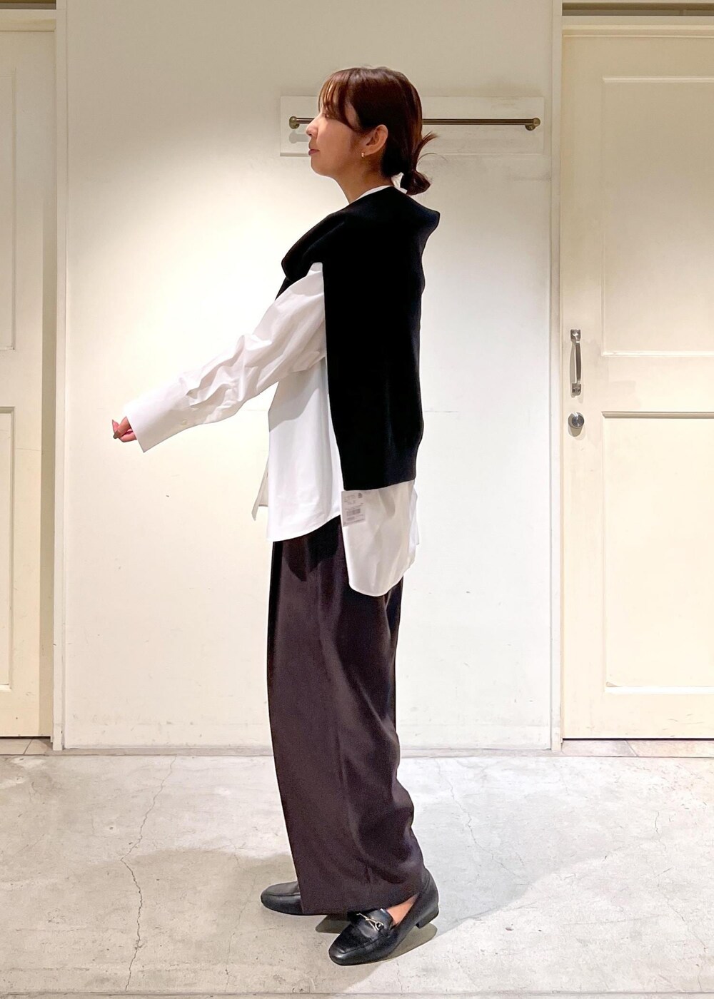 ホワイト系のシャツ/ブラウス、ブラック系のスウェット、ブラウン系のスラックスを着用したレディースの秋コーディネートの3枚目の写真