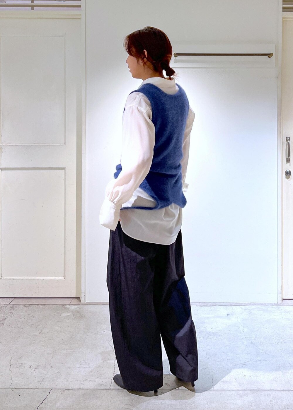 ブルー系のタンクトップ、ホワイト系のシャツ/ブラウス、ブラック系のブーツを着用したレディースの秋コーディネートの6枚目の写真