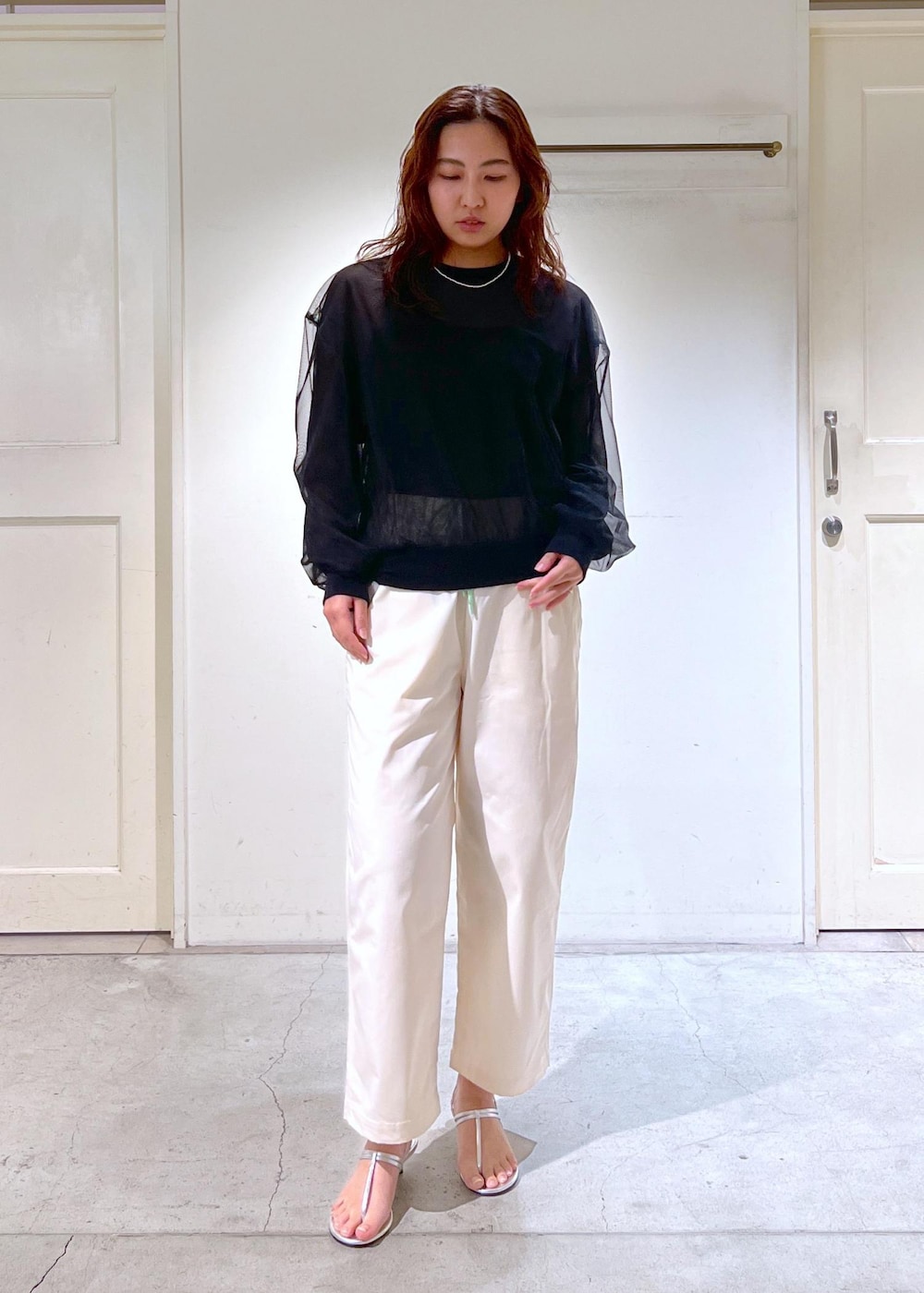 ブラック系のチューブトップ、シルバー系のサンダル、ブラック系のTシャツ/カットソーを着用したレディースの春コーディネートの3枚目の写真