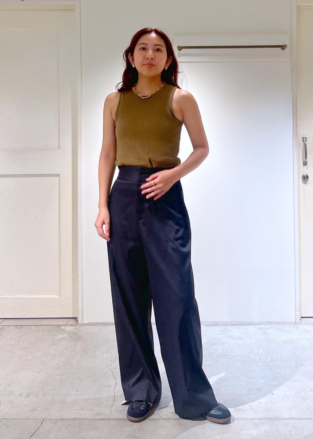 ブラック系のその他パンツ、ホワイト系のハンドバッグ、グリーン系のタンクトップを着用したレディースの夏コーディネートの6枚目の写真