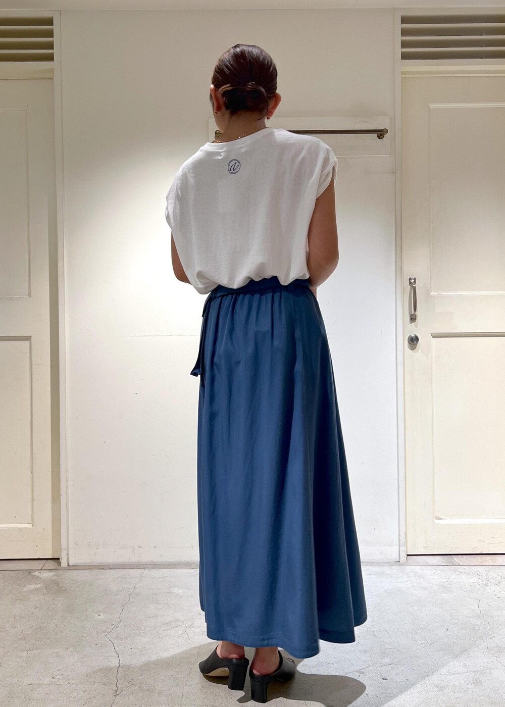 ホワイト系のTシャツ/カットソー、ブルー系のスカート、ブラック系のサンダルを着用したレディースの夏コーディネートの3枚目の写真