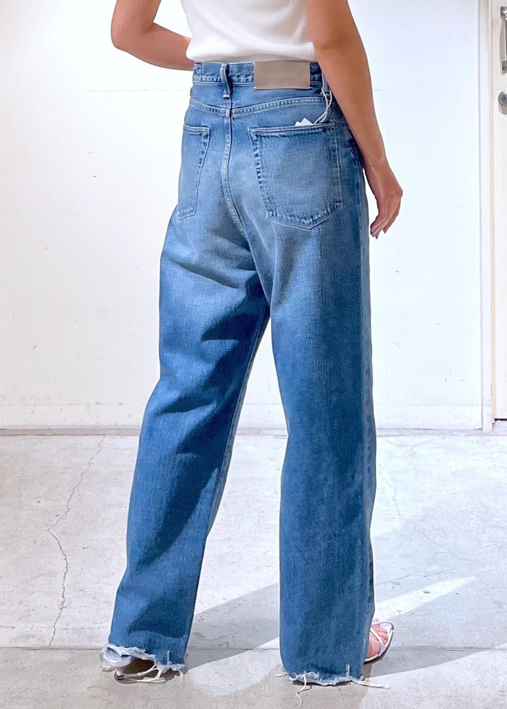 ブルー系のデニムパンツ、シルバー系のサンダル、ホワイト系のかごバッグを着用したレディースの夏コーディネートの6枚目の写真