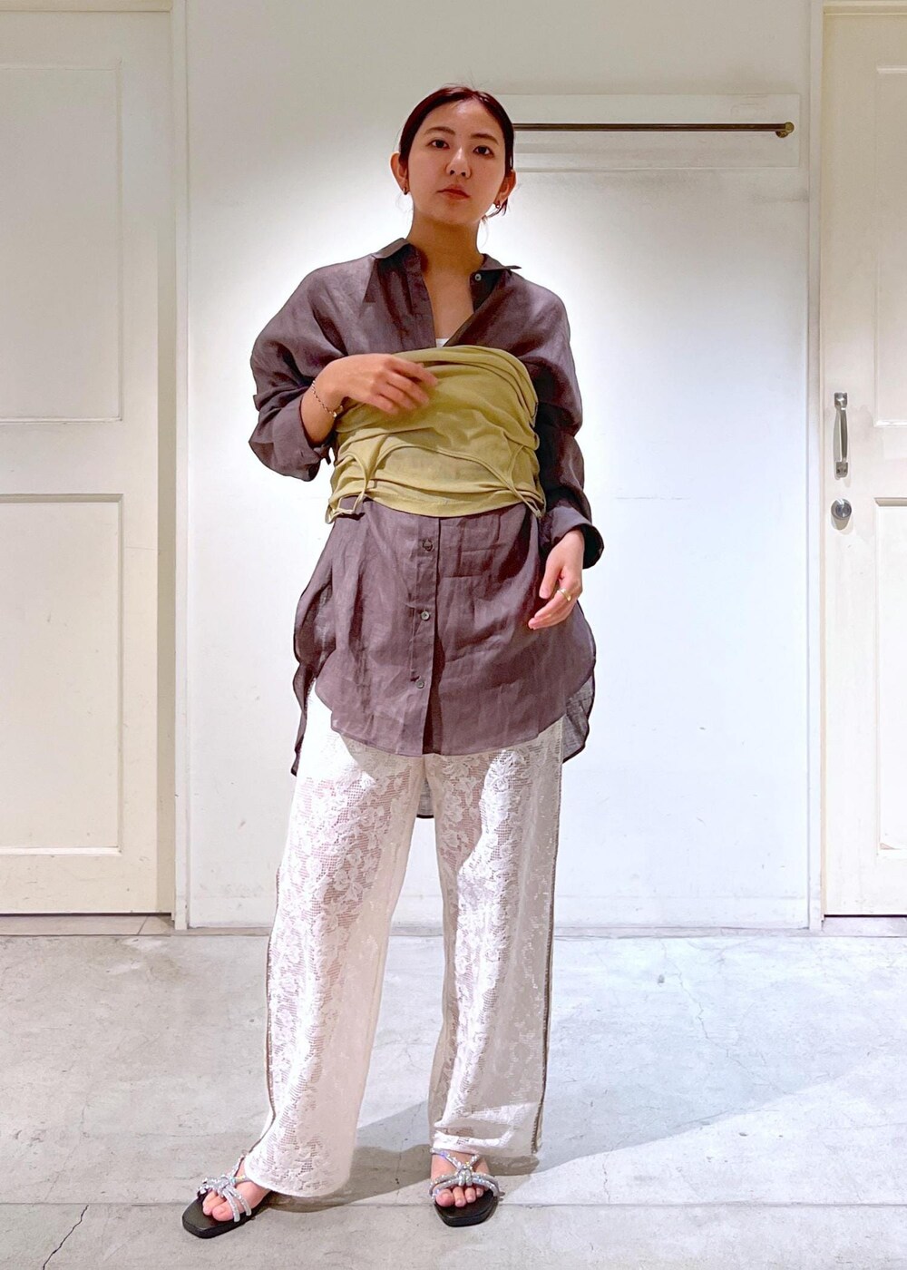 シルバー系のサンダル、ホワイト系のタンクトップ、イエロー系のキャミソールを着用したレディースの夏コーディネートの4枚目の写真