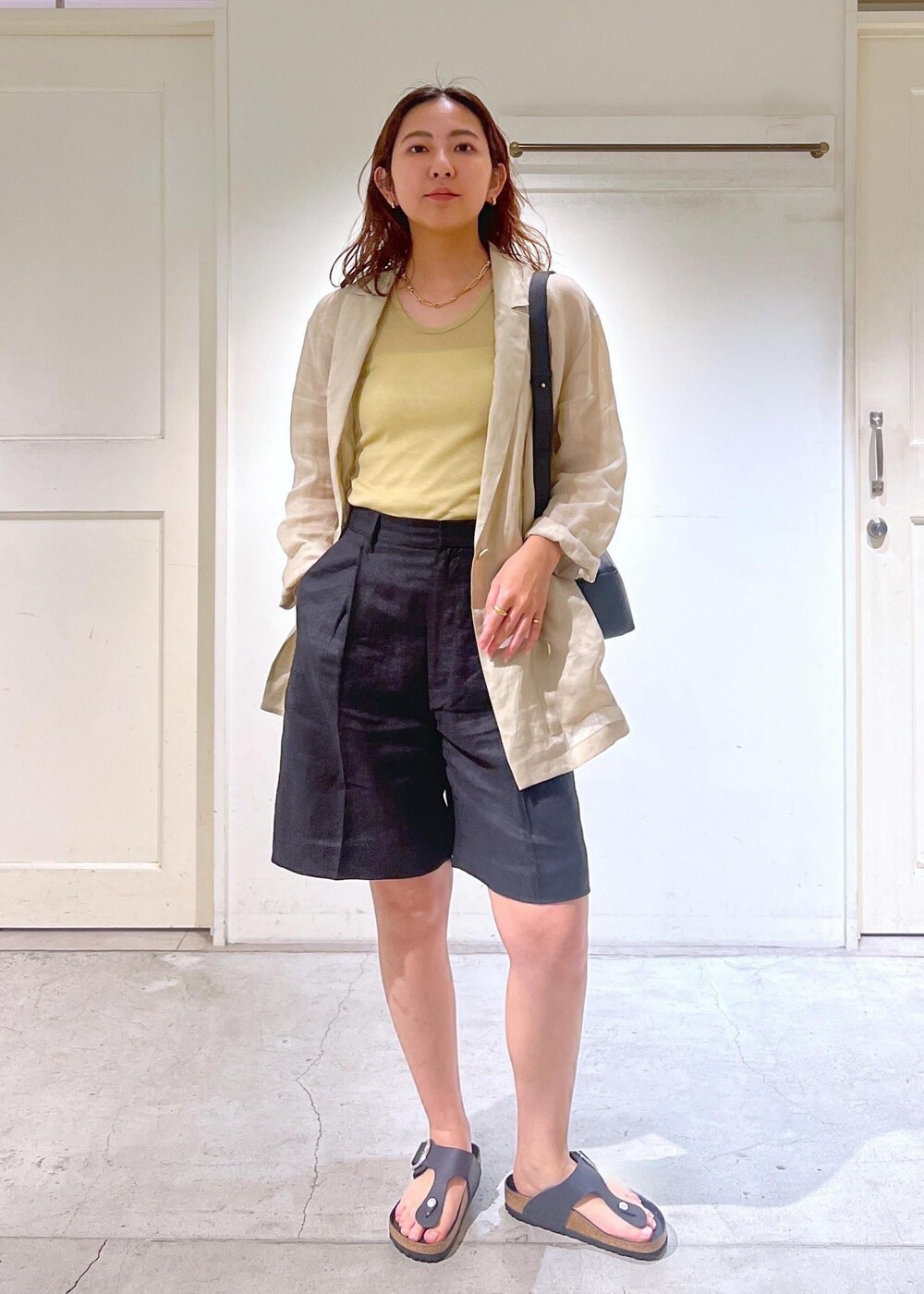 ブラック系のショルダーバッグ、ベージュ系のテーラードジャケット、ブラック系のその他パンツを着用したレディースの夏コーディネートの3枚目の写真