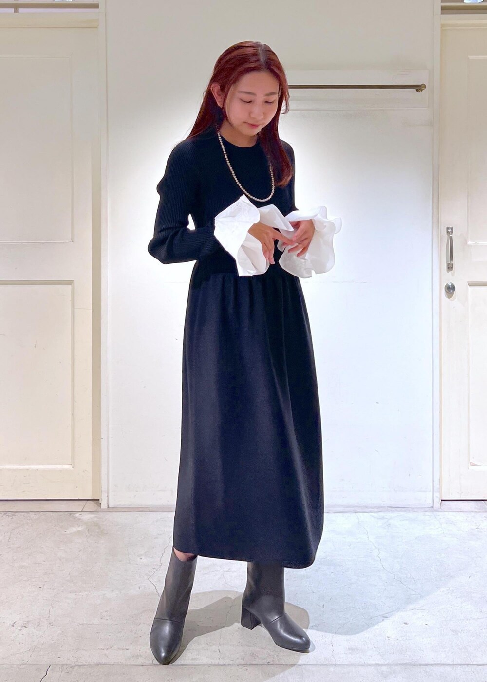 ホワイト系のその他アウター、ブラック系のブーツ、ブラック系のワンピースを着用したレディースの冬コーディネートの4枚目の写真