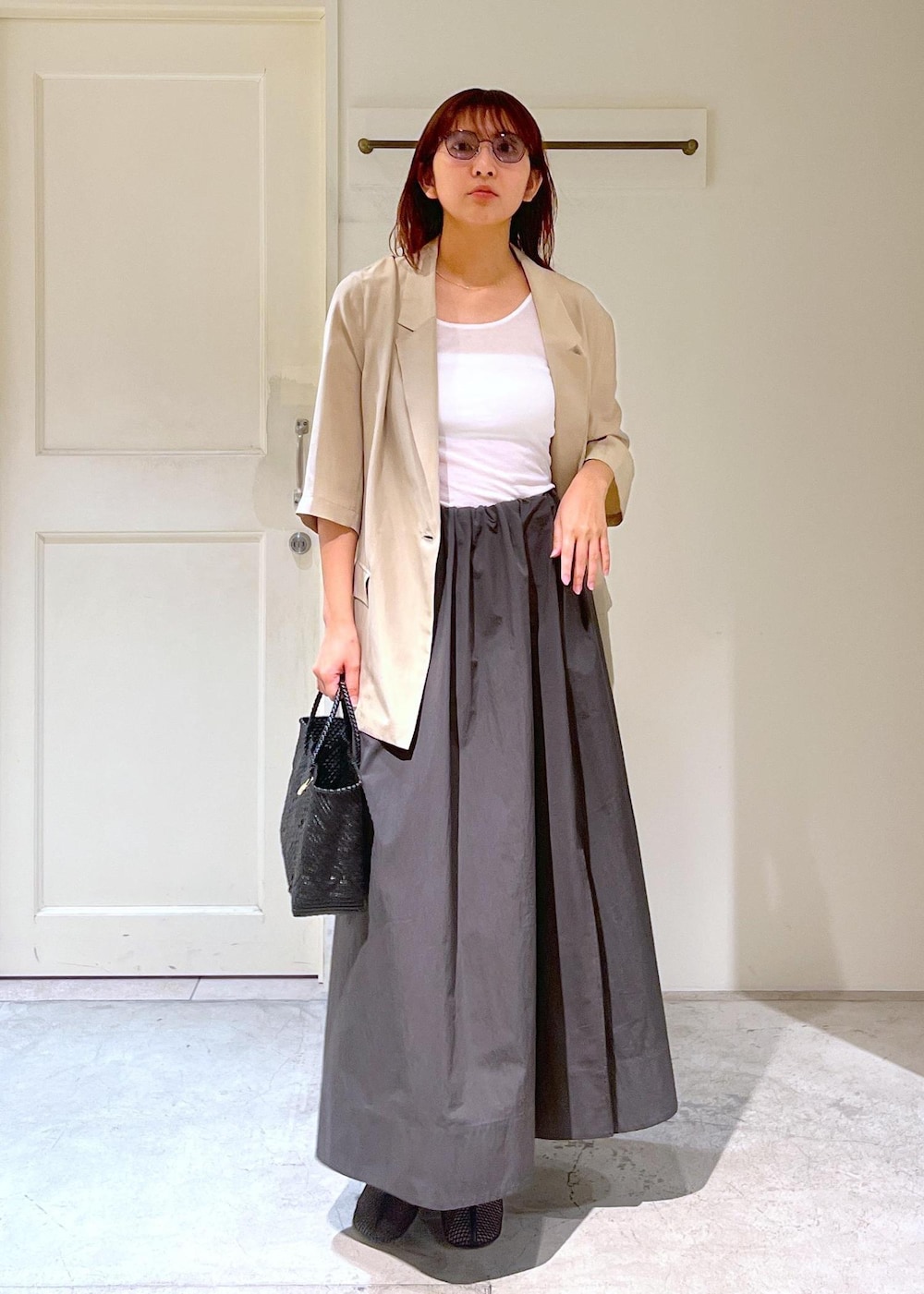 ブラック系のかごバッグ、ベージュ系のシャツ/ブラウス、グレー系のスカートを着用したレディースの春コーディネートの4枚目の写真