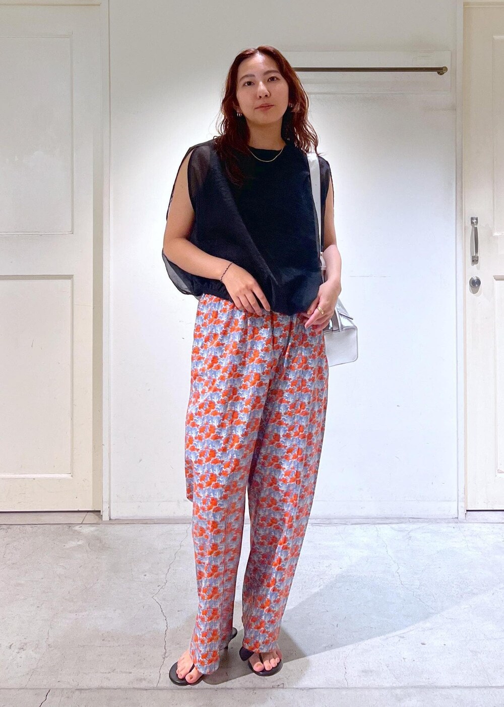 シルバー系のショルダーバッグ、ブラック系のサンダル、ブラック系のTシャツ/カットソーを着用したレディースの夏コーディネートの2枚目の写真