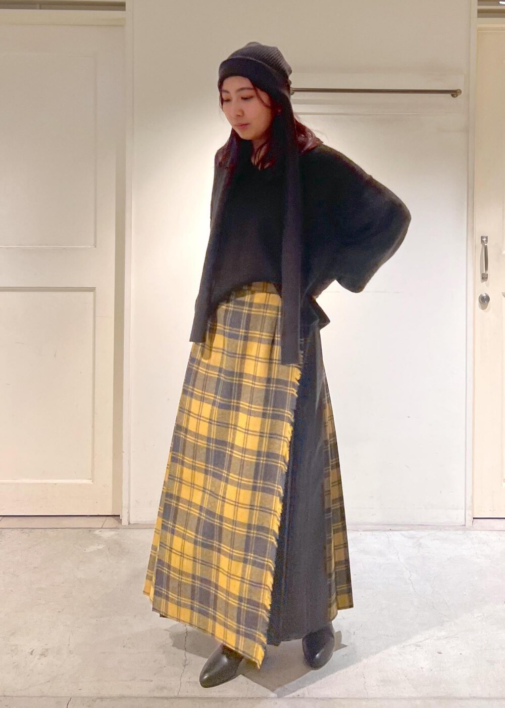 イエロー系のスカート、ブラック系のブーツ、ブラウン系のニット/セーターを着用したレディースの秋コーディネートの4枚目の写真